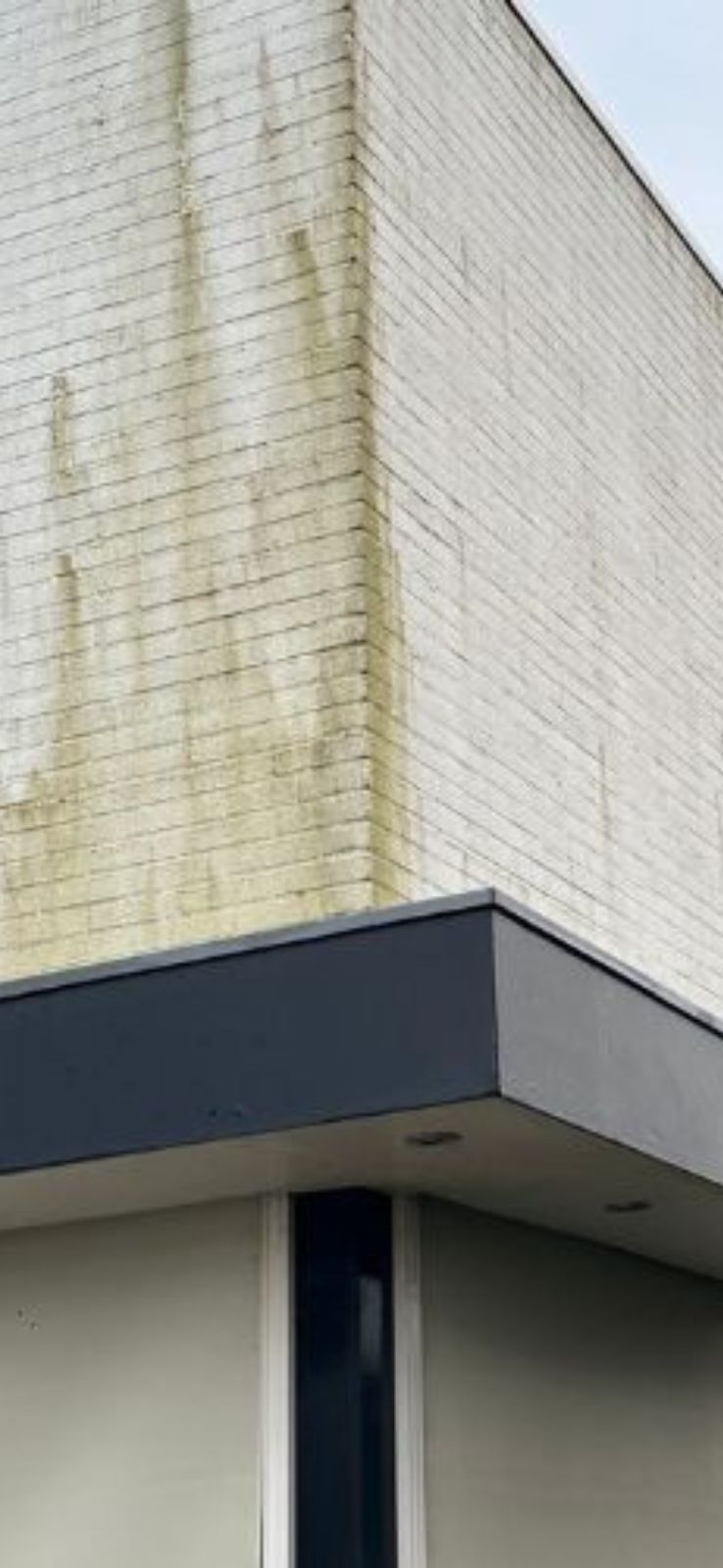 Hoek van gebouw met witte bakstenen muur.