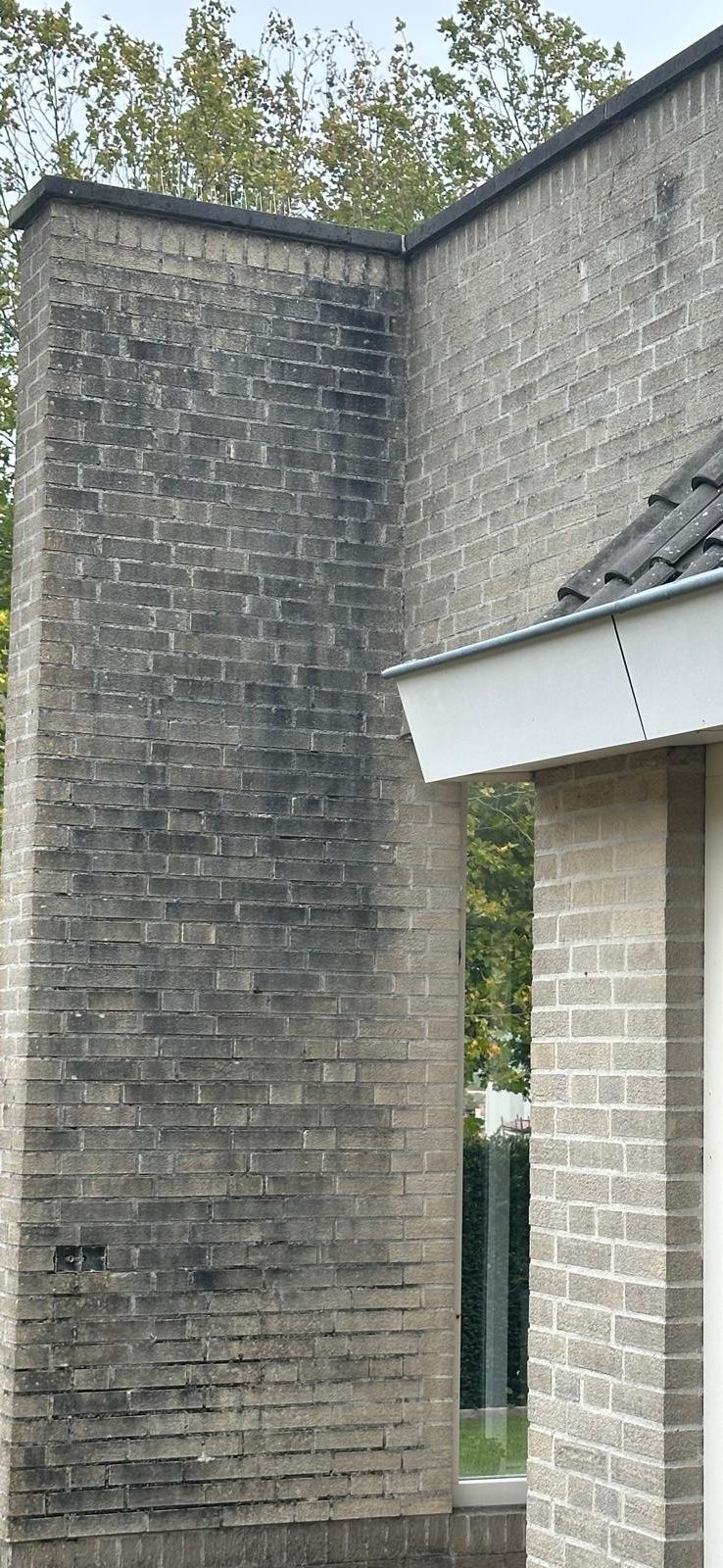 Roetvlekken op bakstenen muur.